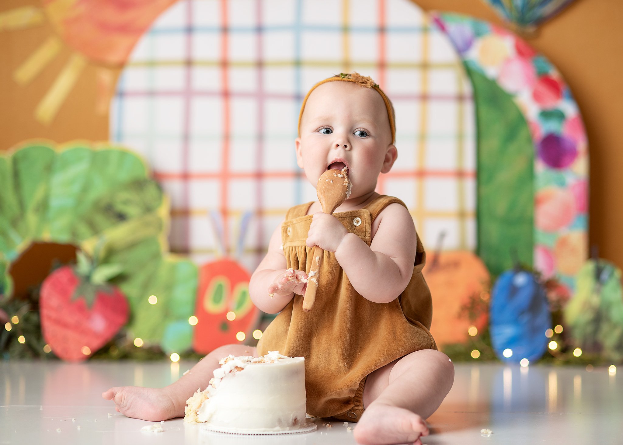baby girl eating cake at a professional photo studio in lincoln nebraska